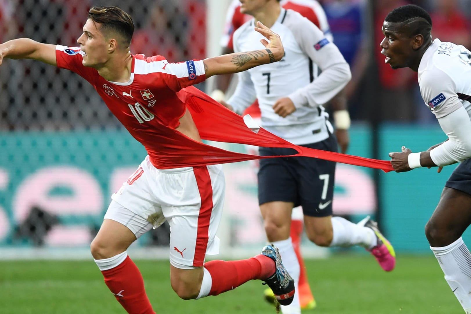 Kuriose Szenen bei der EM: Paul Pogba (re.) zieht, das Trikot von Granit Xhaka reißt.