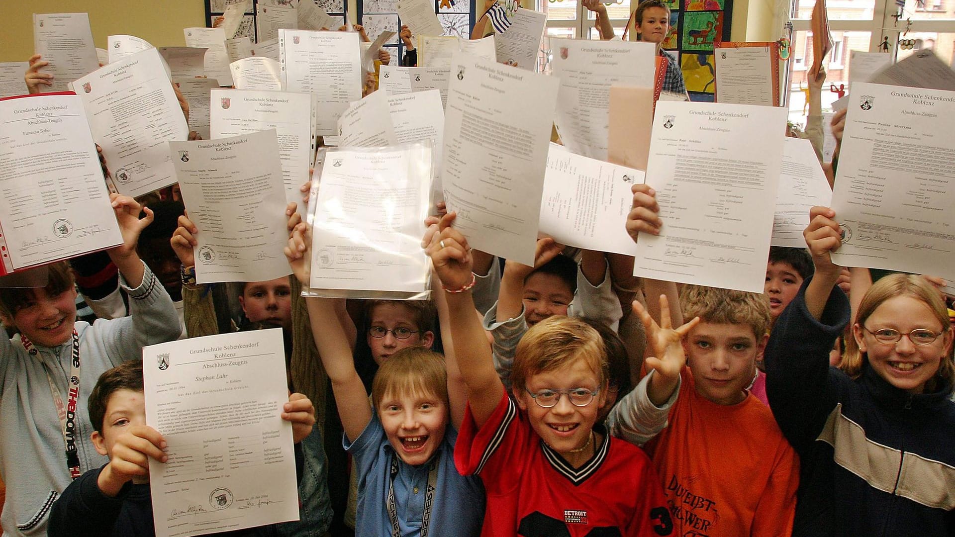 Grundschulkinder präsentieren stolz ihre Zeugnisse am Ende des Schuljahres.