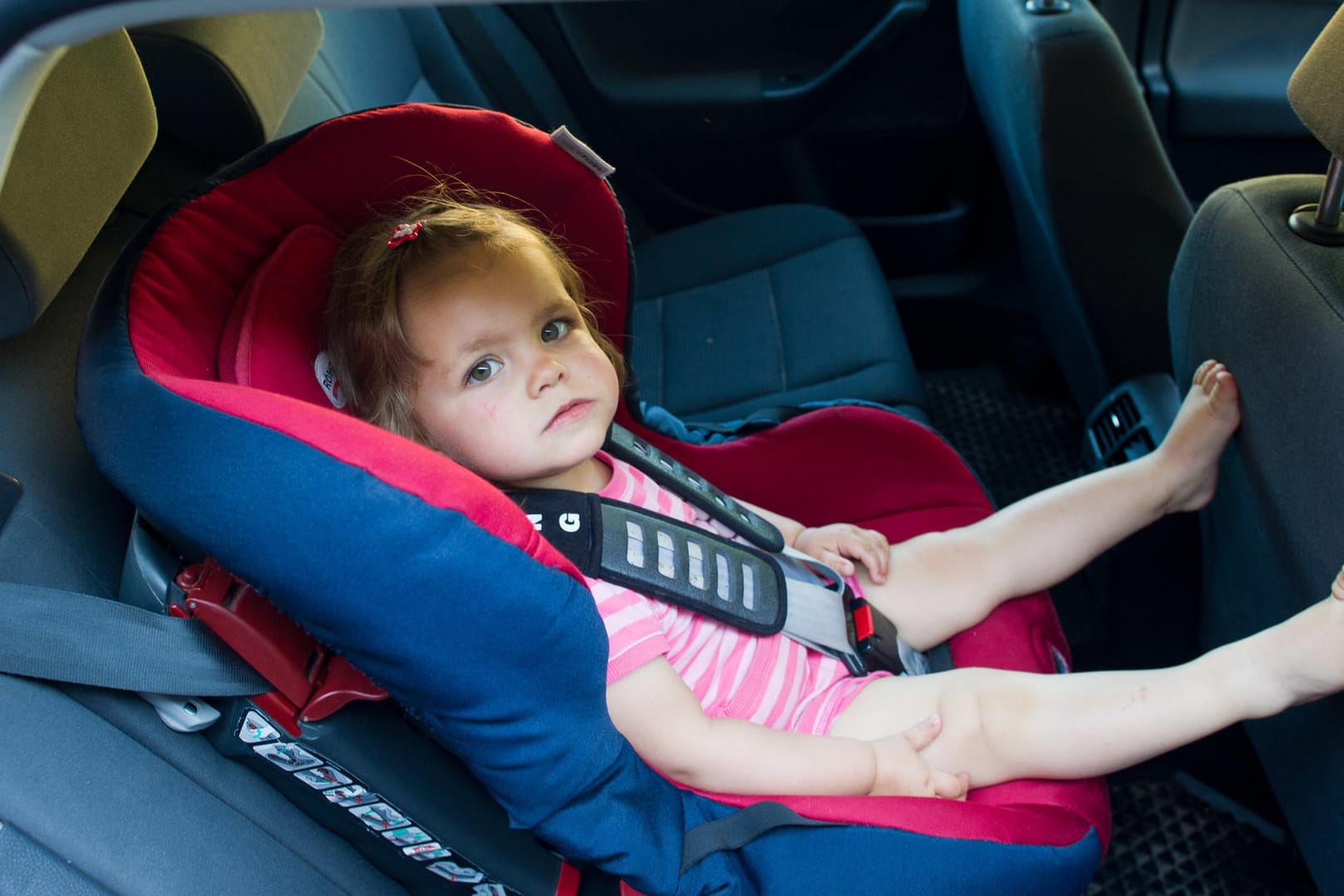 Die Oberfläche von Kindersitzen in Pkw kann sich im Sommer so stark aufheizen, dass die Kinder Verbrennungen erleiden.