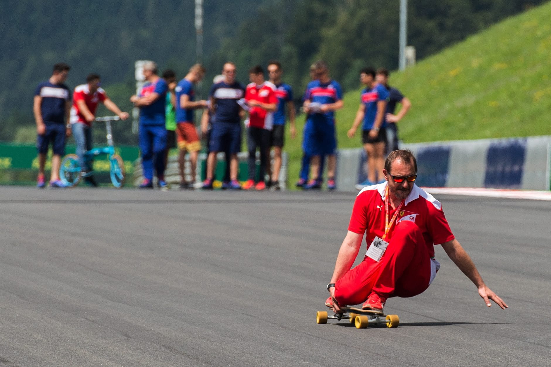 Gewagte Aktion: Ein Ferrari-Mitarbeiter fährt mit einem Skatebord auf der Strecke in Spielberg eine Abfahrt hinunter.