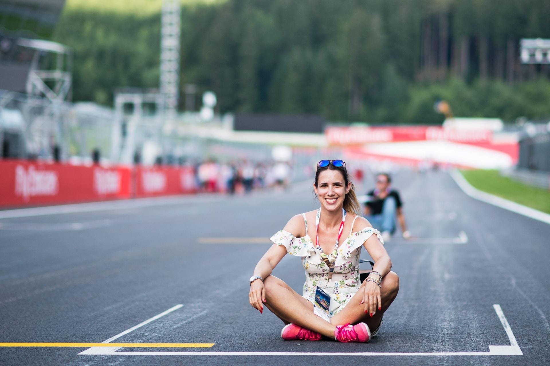 Formel 1 zum Anfassen: Ein weiblicher Fan sitzt auf der Rennstrecke in der Startaufstellung.