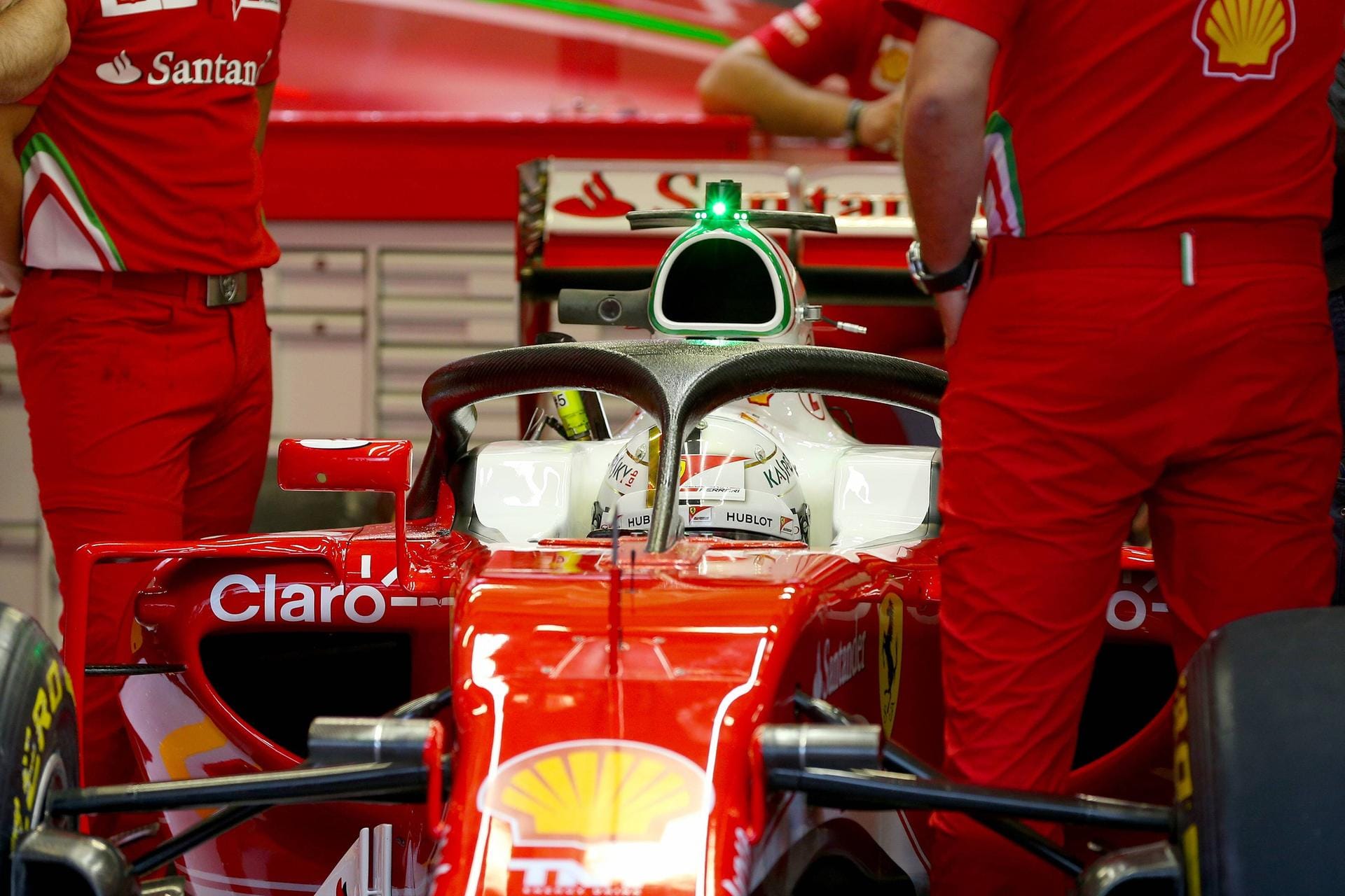Dach über dem Kopf: Ferrari-Pilot Sebastian Vettel steht in der Box mit einer verbesserten Version des Halo-Sicherheitssystems. Zum Test kam es am Freitag wegen des Unwetters im zweiten Training nicht.