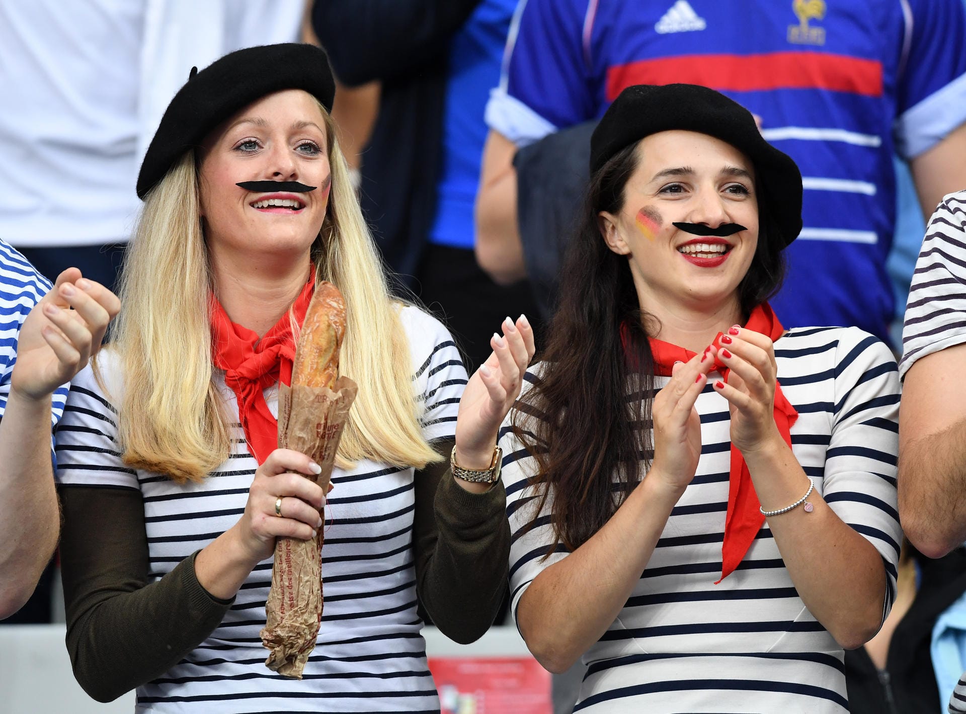 Die Fans der Equipe Tricolore haben sich stereotypisch herausgeputzt: Diese beiden weiblichen Fans bestechen durch französische Markenzeichen wie Mustache und Baskenmütze...