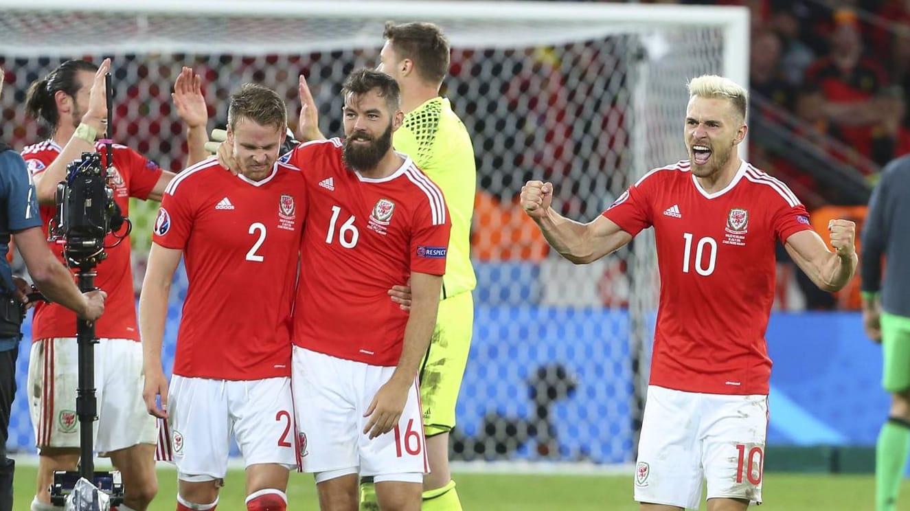 Die beiden Waliser Chris Gunter und Joe Ledley (v.li.) feiern mit Teamkollege Aaron Ramsey (re.) den Sieg gegen Belgien.