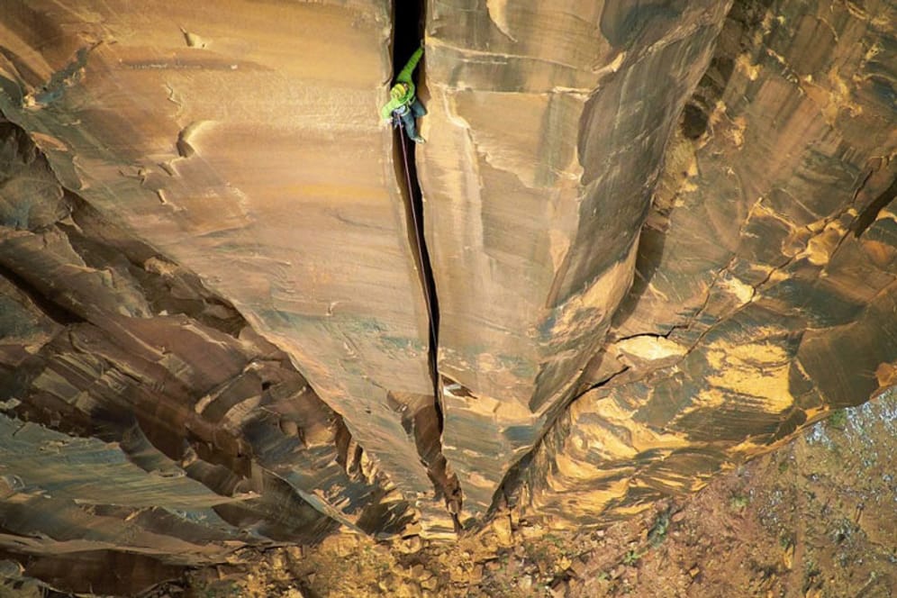 Aus der Vogelperspektive ein atemberaubender Anblick: Ein Kletterer steigt in Moab (USA) einen gut 120 Meter hohen Spalt in einer Felswand hinauf.