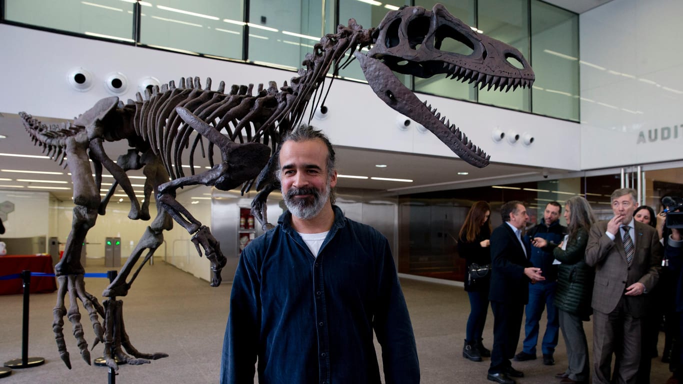 Der argentinische Paläontologe Sebastian Apesteguia posiert vor einer Replik des entdeckten Saurierskeletts.