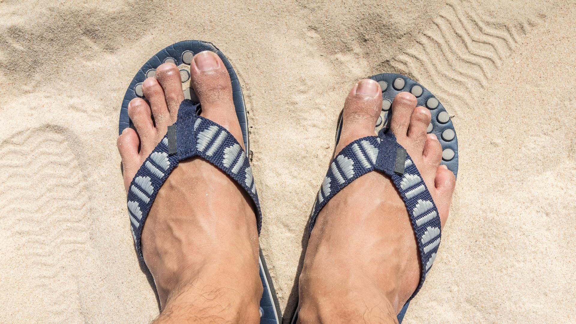 Im Sand natürlich praktisch, aber Männerfüße in Sandalen sind leider selten so ein schöner Anblick wie hier.