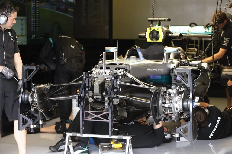 Die Ingenieure untersuchen das Auto von Lewis Hamilton nach dessen Crash.