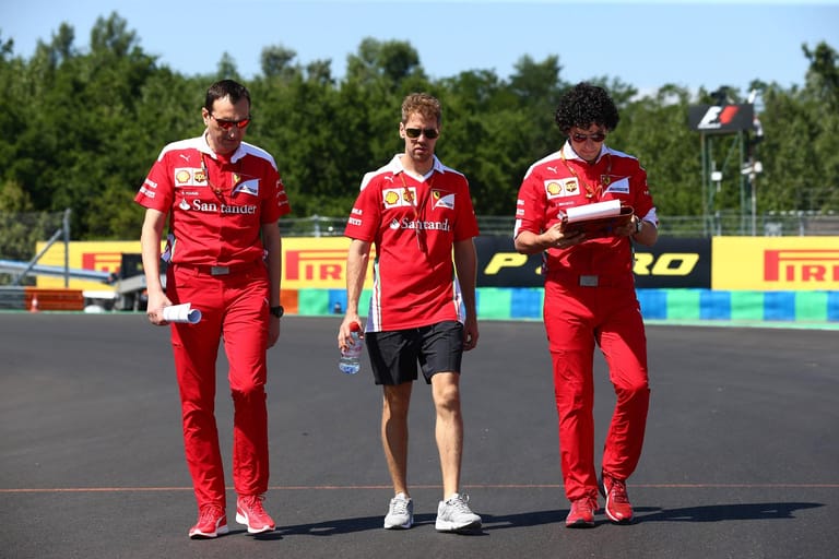 Sebastian Vettel inspiziert zu Fuß die Rennstrecke.