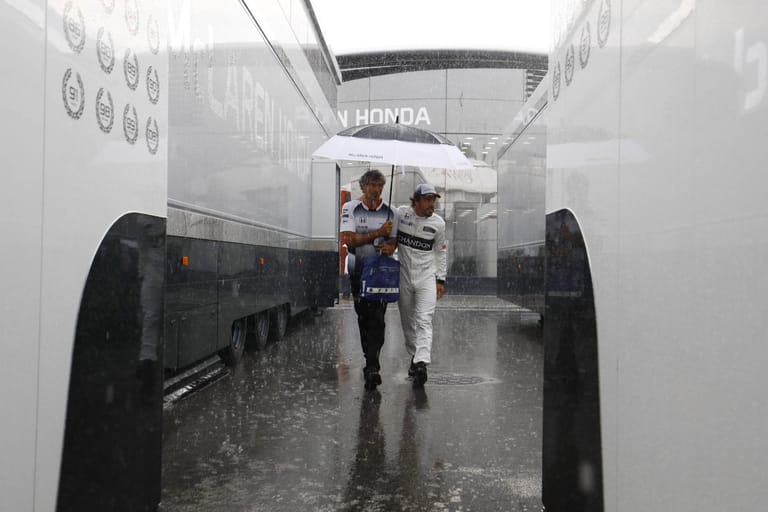Kurz vor Beginn des Qualifyings setzt der Regen ein. Fernando Alonso läuft gut beschirmt durchs Fahrerlager.