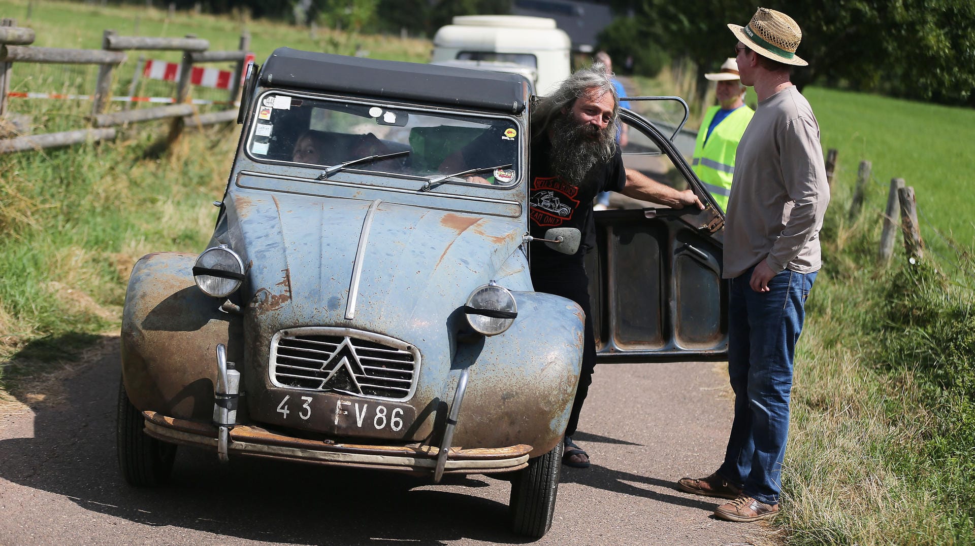 Der Fahrer eines als Ente bezeichneten Citroën 2CV kommt in Mechernich mit seinem rostigen Fahrzeug zum Deutschlandtreffen.