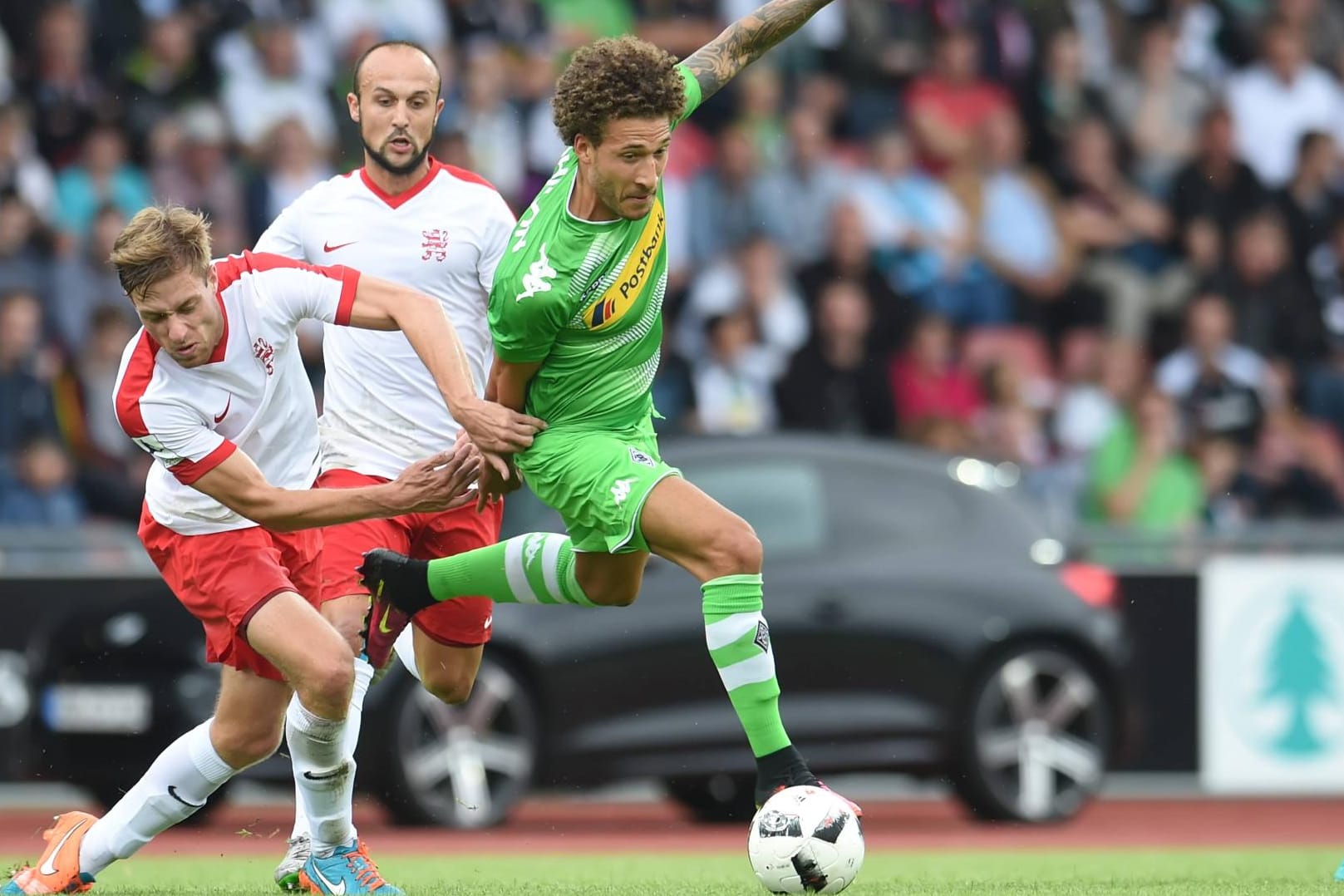 Gladbachs Fabian Johnson Gladbach (re.) wird von zwei Kassel-Spielern verfolgt.