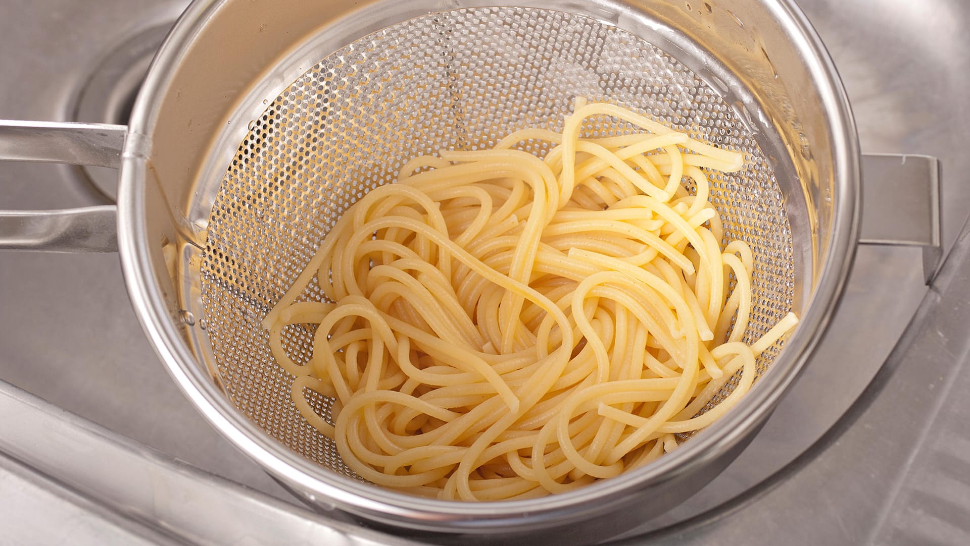 Abseihen von heißem Wasser beim Kochen von Nudeln.