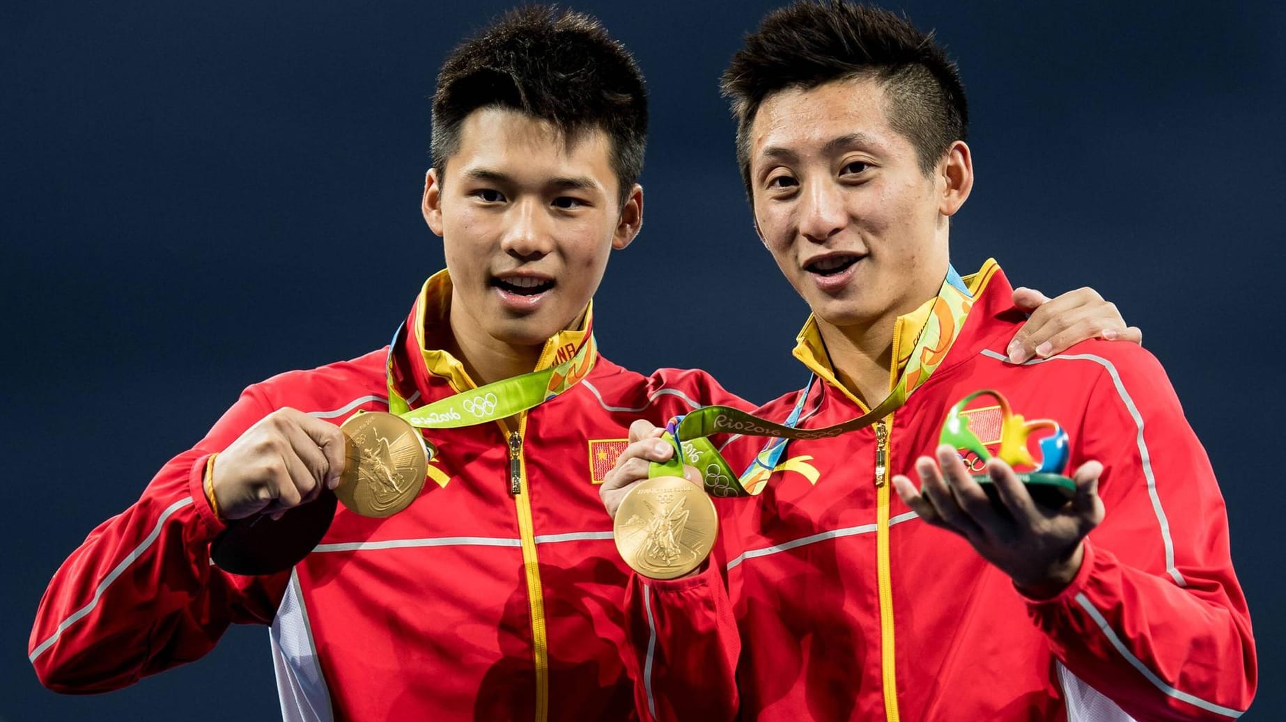 Die chinesischen Synchronspringer Aisen Chen und Yue Lin präsentieren stolz ihre Goldmedaillen. Die chinesischen Synchronspringer Aisen Chen und Yue Lin präsentieren stolz ihre Goldmedaillen.