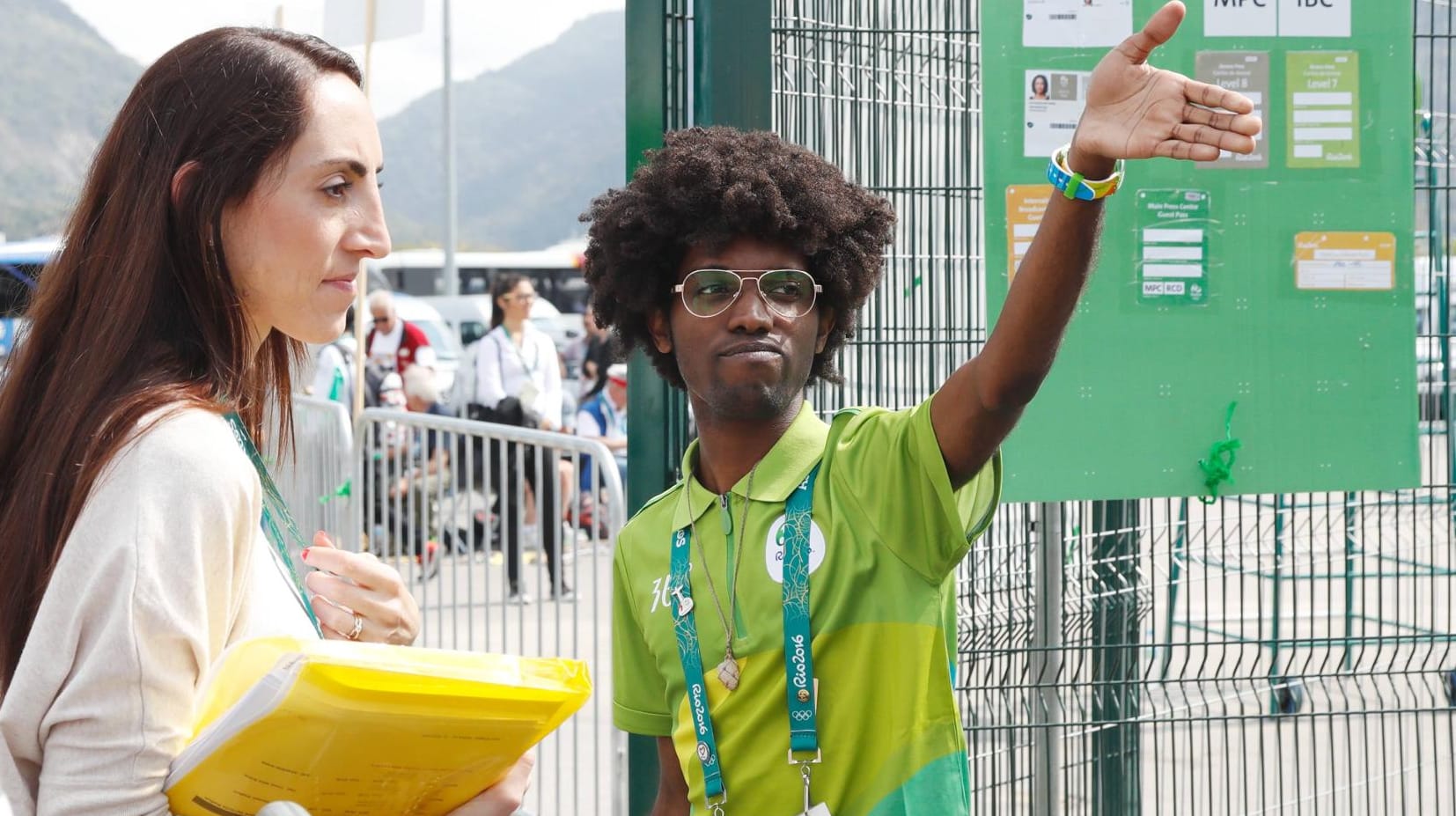 Ein Volunteer zeigt einer jungen Dame den Weg.