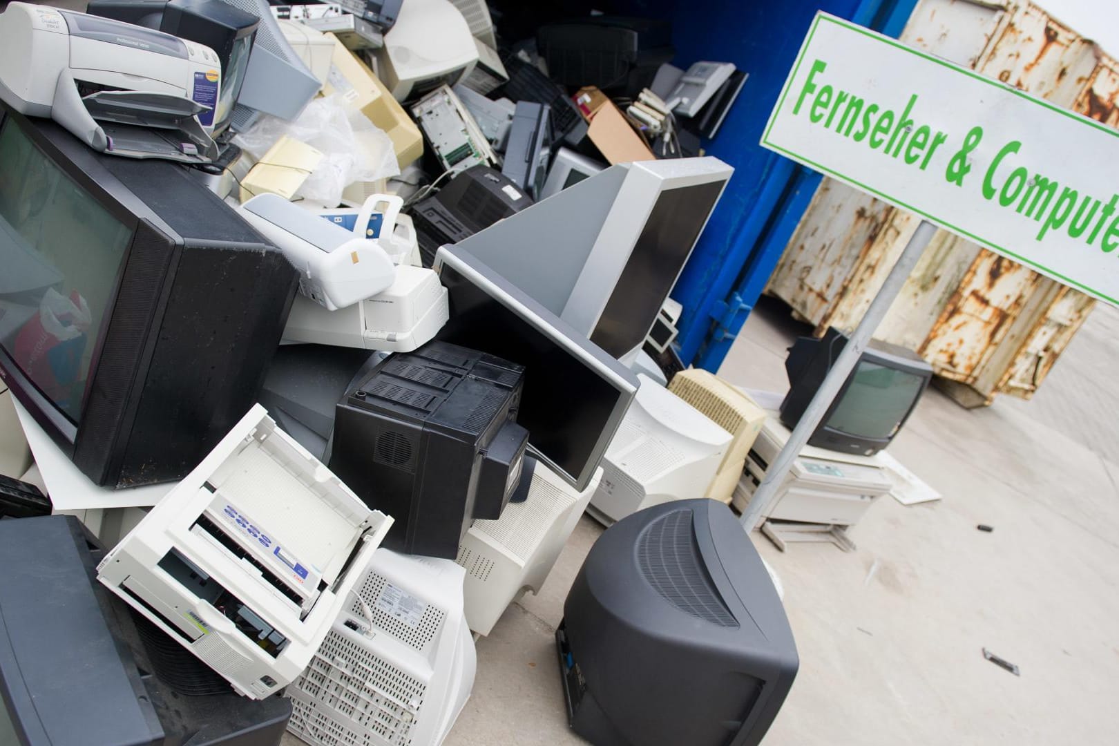 Entsorgte Computer, Fernseher, Monitore und Drucker in einem Entsorgungsbetrieb.