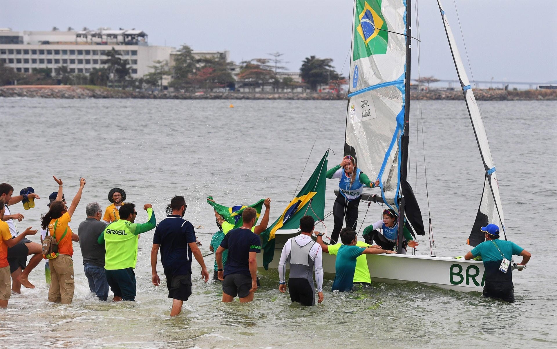 Großer Empfang für die neuen Olympiasiegerinnen in der 49er Bootsklasse im Segeln: Nach ihrem Gewinn der Goldmedaille werden die Brasilianerinnen Martine Soffiatti Grael und Kahena Kunze von ihren Landsleuten im flachen Uferbereich gefeiert.