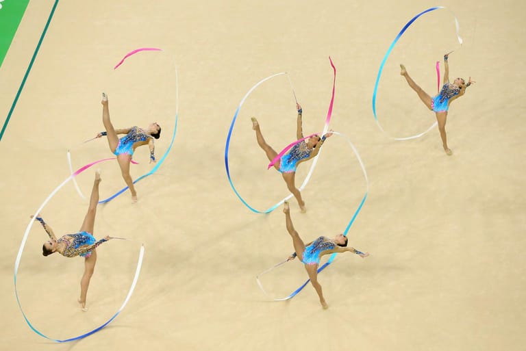 Im Mannschaftswettbewerb der Rhythmischen Sportgymnastik kommt es darauf an, die grazilen Bewegungen möglichst synchron auszuführen. So wie hier beim Team der USA.