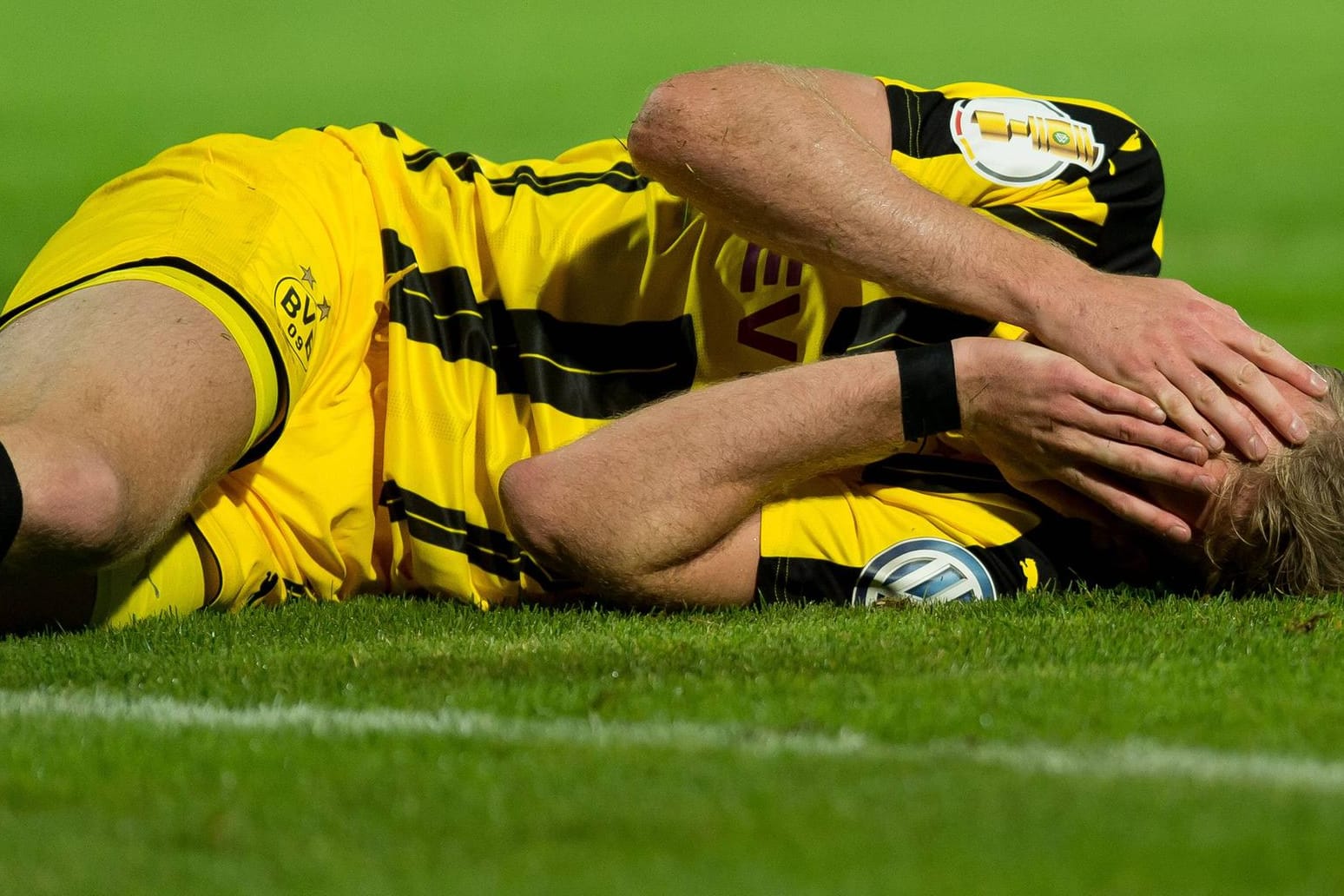 André Schürrle krümmt sich nach dem Fausthieb des Trierer Keepers auf dem Boden.