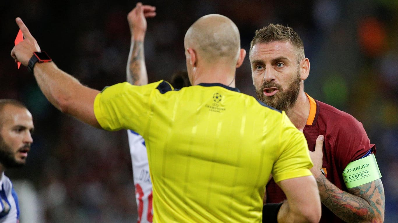 Roma-Kapitän Daniele De Rossi (re.) wird von Schiedsrichter Szymon Marciniak des Feldes verwiesen.