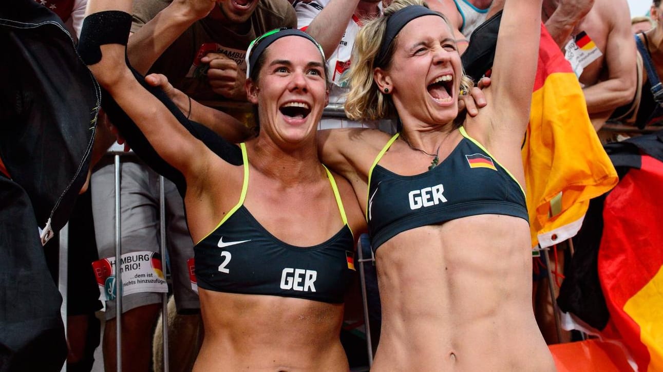 Kira Walkenhorst (l.) und Laura Ludwig (r.) jubeln mit Fans nach dem Finalsieg.