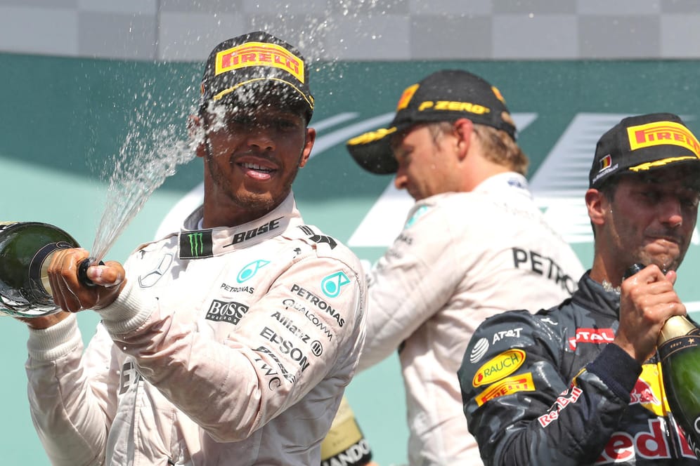 Obligatorische Sektdusche: Lewis Hamilton (links) feiert seinen dritten Platz in Spa.