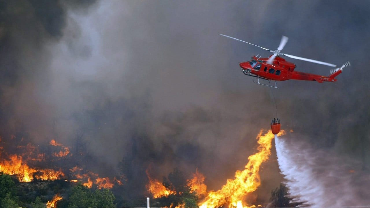 Von einem Helikopter aus versuchen Feuerwehrkräfte einen Brand mit Löschmittel im Naturschutzgebiet La Granadella in Valencia zu löschen. Von einem Helikopter aus versuchen Feuerwehrkräfte einen Brand mit Löschmittel im Naturschutzgebiet La Granadella in Valencia zu löschen.