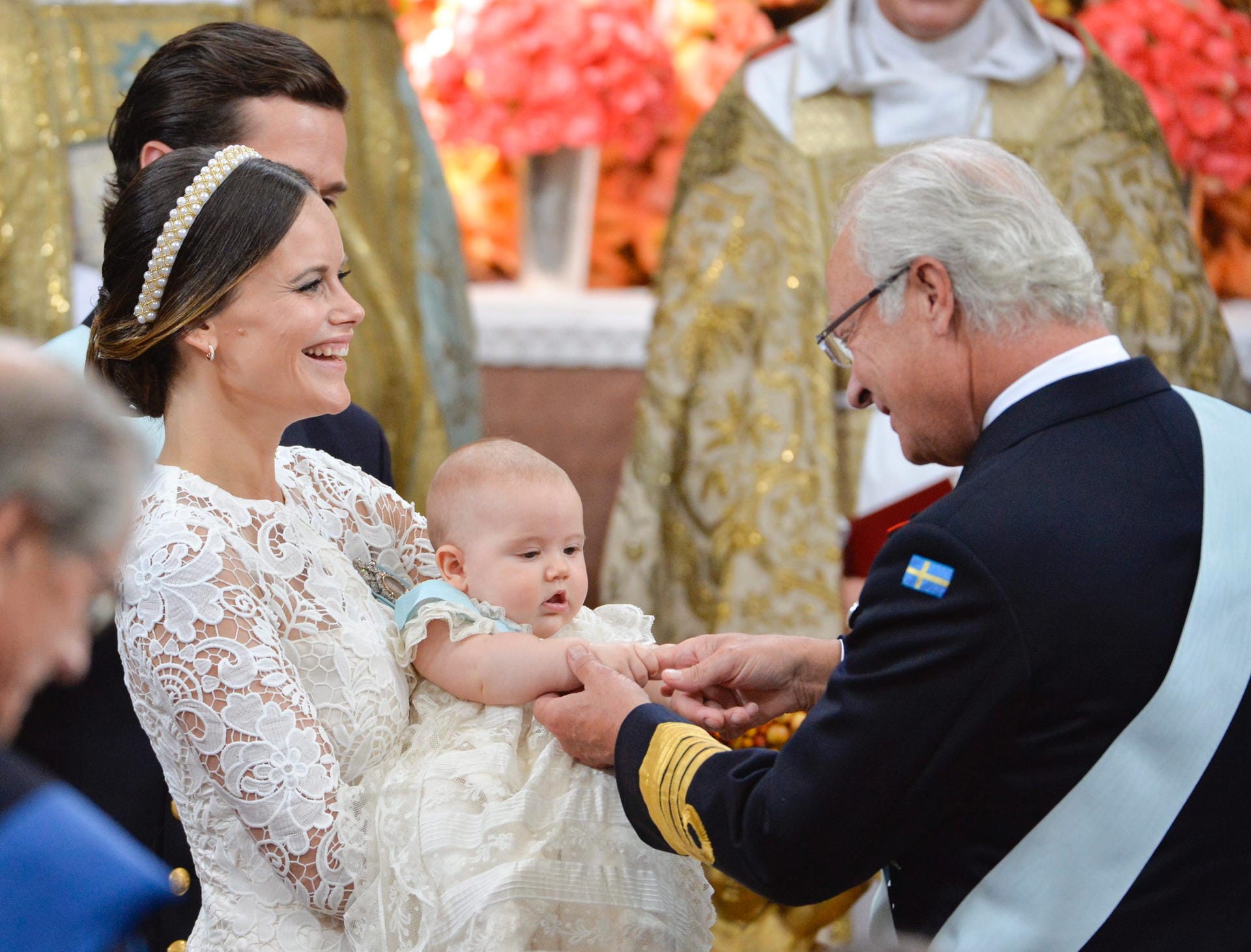 Der Kleine will die Hand von Opa Carl XVI Gustaf gar nicht mehr loslassen, als der ihm seinen ersten Orden ans Taufkleid steckt.