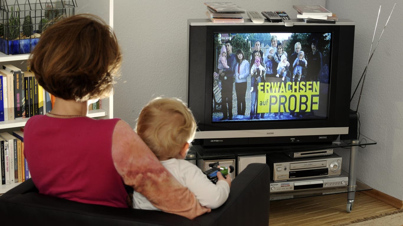 Eine Mutter sieht sich mit ihrem Sohn die RTL-Sendung "Erwachsen auf Probe" an. In der umstrittenen Sendung aus dem Jahr 2009 sollten Teenagerpaare das Elternsein ausprobieren, dazu stellten andere Eltern ihre Babys und Kleinkinder zur Verfügung.
