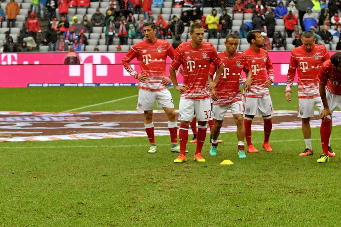 Die Bayern-Spieler machen sich gegen Ingolstadt auf dem lädierten Rasen warm.