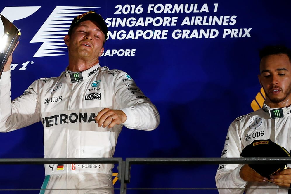Nico Rosberg (links) feiert in Singapur, Lewis Hamilton schaut nachdenklich auf den Boden.