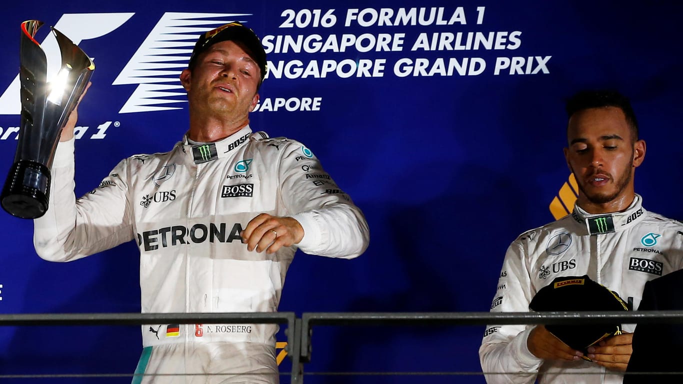 Nico Rosberg (links) feiert in Singapur, Lewis Hamilton schaut nachdenklich auf den Boden.