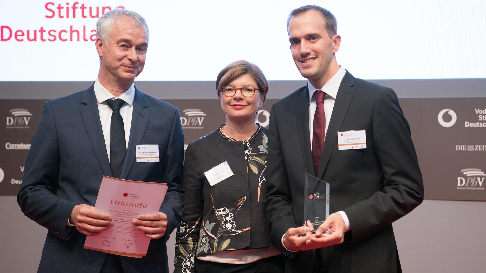 Die Gewinner des 1. Preises des "Deutschen Lehrerpreises - Unterricht innovativ", Schulleiter Stefan Gönnheimer (l) und Lehrer Patrick Bronner vom Friedrich-Gymnasium Freiburg (Baden-Württemberg), stehen in Berlin neben Ingrid M. Haas, Vorstandsmitglied der Vodafone-Stiftung