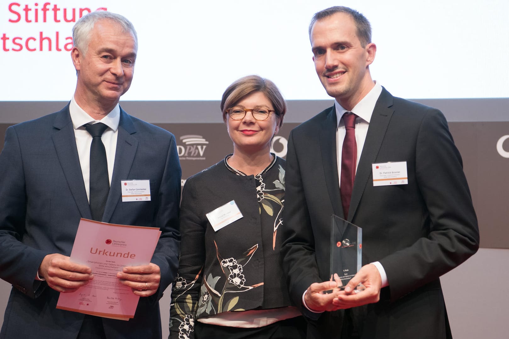 Die Gewinner des 1. Preises des "Deutschen Lehrerpreises - Unterricht innovativ", Schulleiter Stefan Gönnheimer (l) und Lehrer Patrick Bronner vom Friedrich-Gymnasium Freiburg (Baden-Württemberg), stehen in Berlin neben Ingrid M. Haas, Vorstandsmitglied der Vodafone-Stiftung