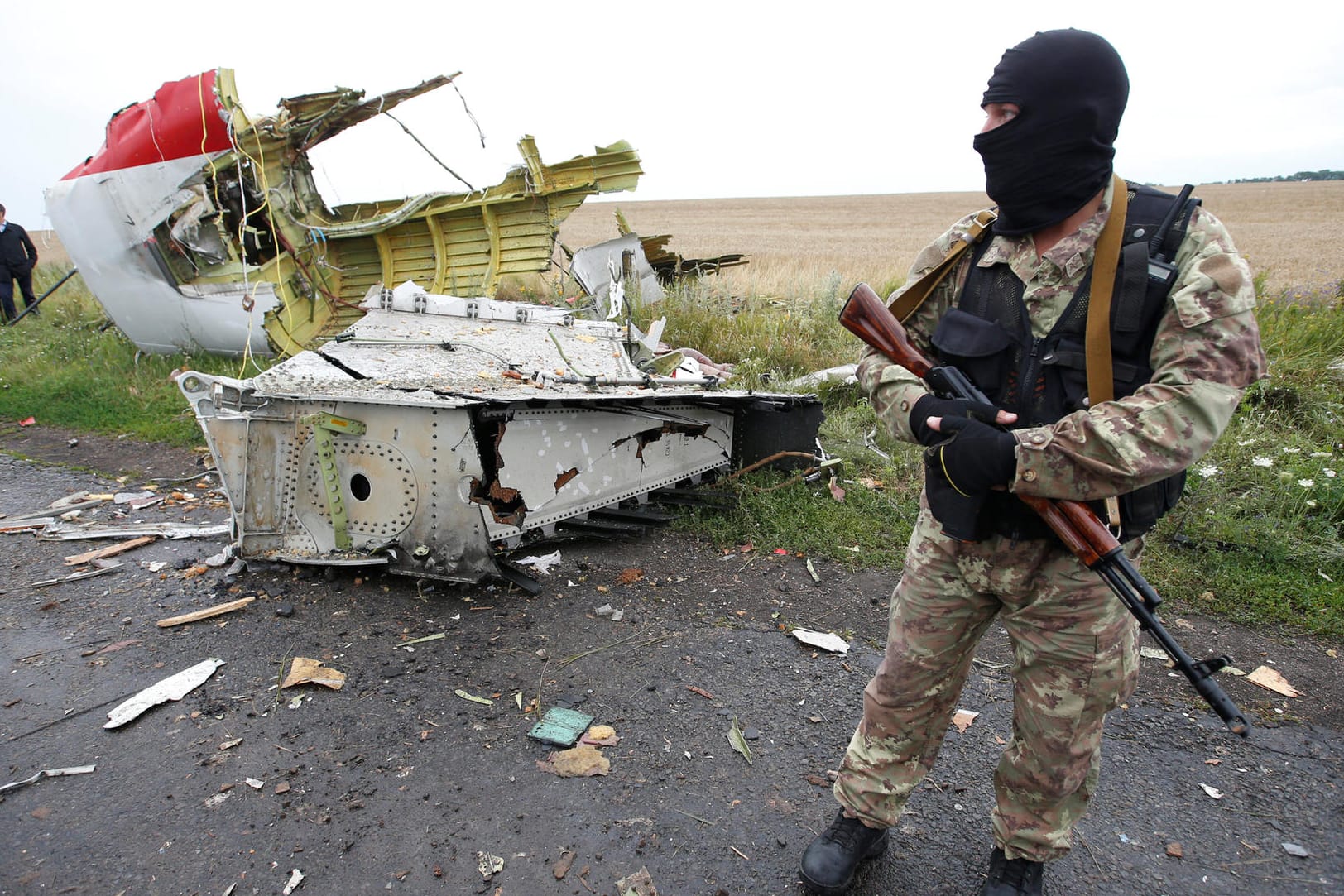 Ein pro-russischer Separatist vor Trümmerteilen der Malaysia-Airlines-Maschine MH17.
