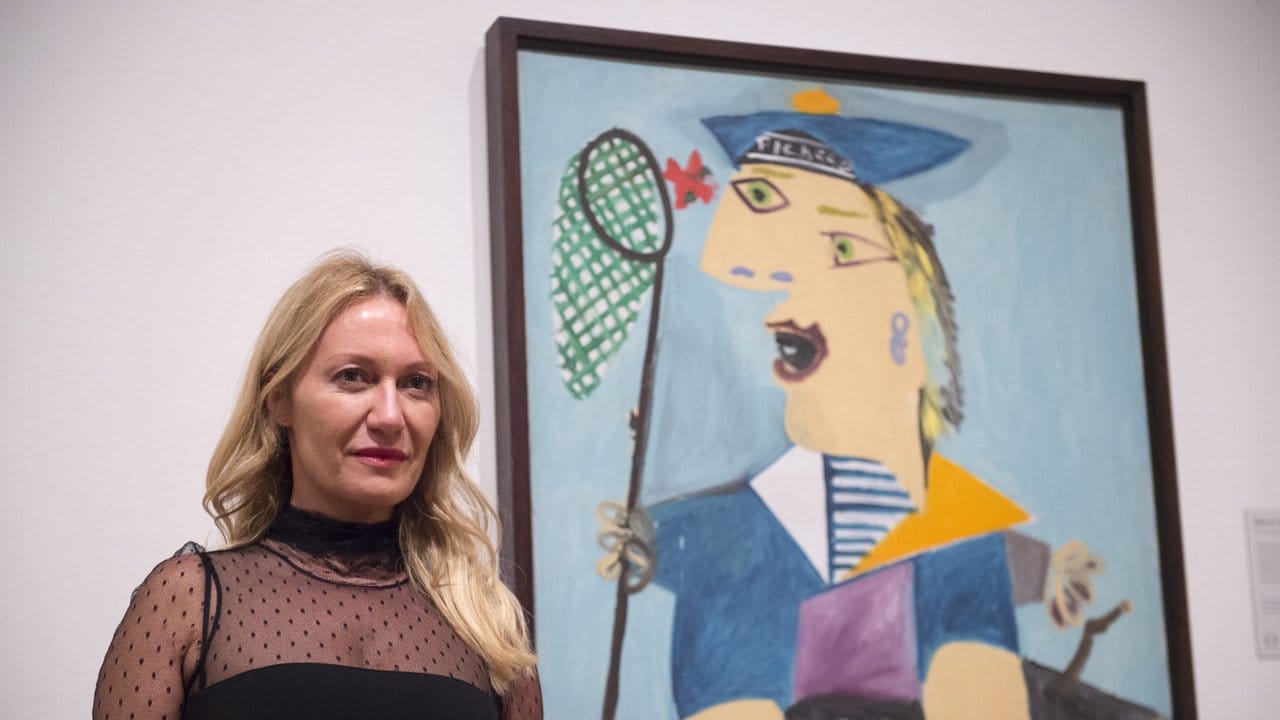 Picasso-Enkelin Diana Widmaier Picasso neben einem Porträt ihrer Mutter Maya Widmaier Picasso.