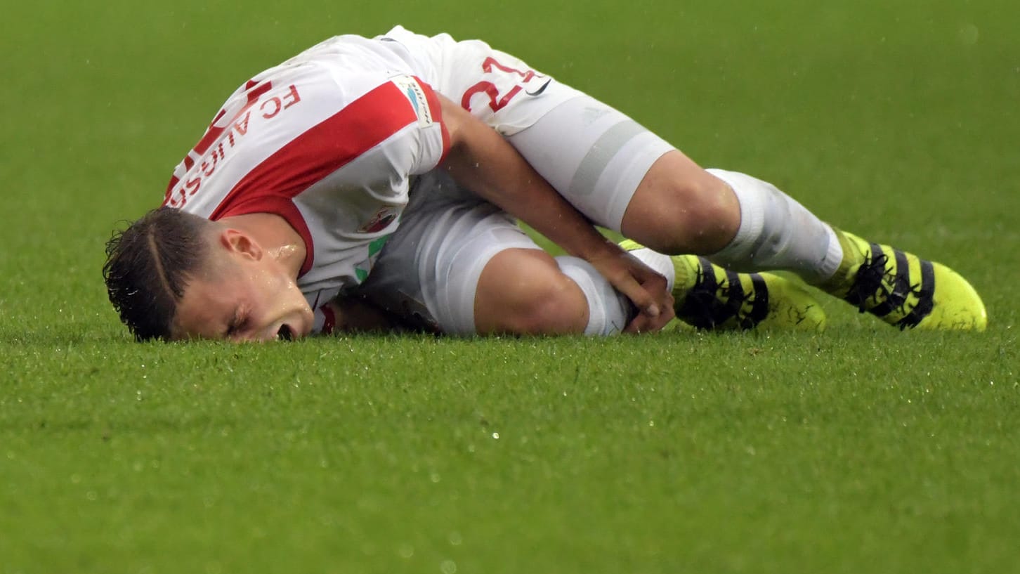 Der Augsburger Dominik Kohr krümmt sich nach dem Foul von José Rodriguez vor Schmerzen auf dem Boden. Der Augsburger Dominik Kohr krümmt sich nach dem Foul von José Rodriguez vor Schmerzen auf dem Boden.