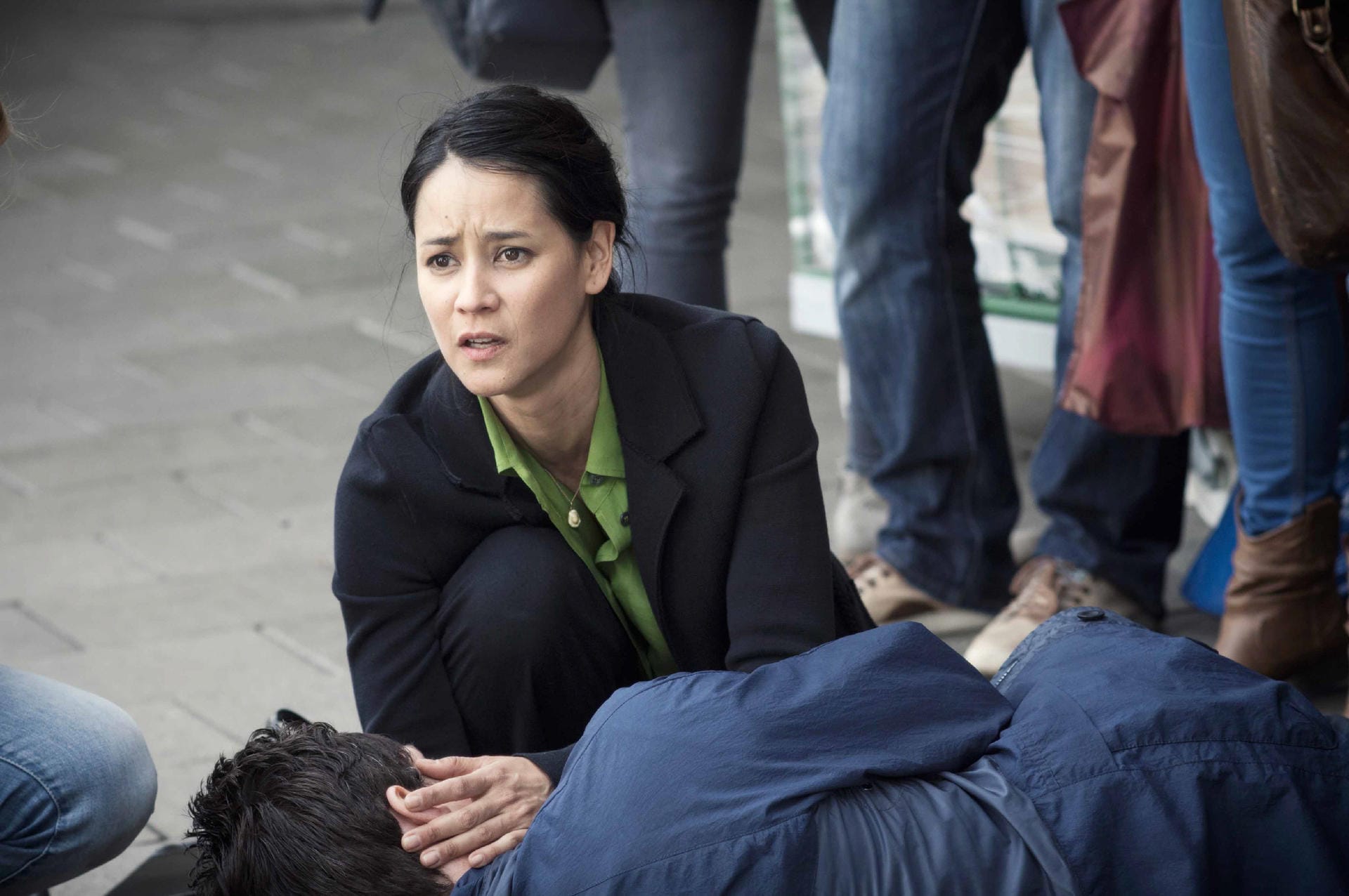 Ayumi Schröder (Luka Omoto) kniet vor ihrem Mann, der gerade auf offener Straße von einem Unbekannten niedergestochen worden ist. Mit diesem Verbrechen beginnt der "Tatort: Die Wahrheit".