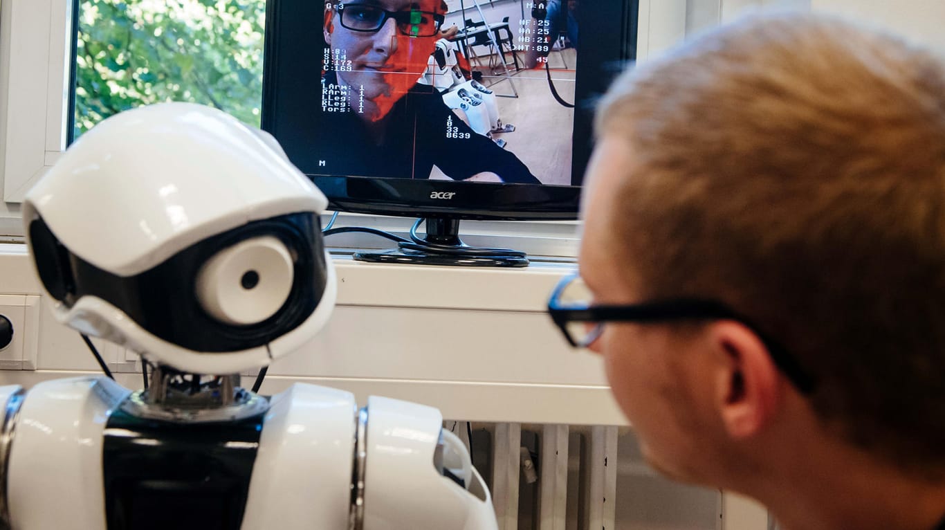 Der Projektleiter des "Myon"-Projektes, Benjamin Panreck, betrachtet am das Kameraauge eines aktivierten "Myon"-Roboter.