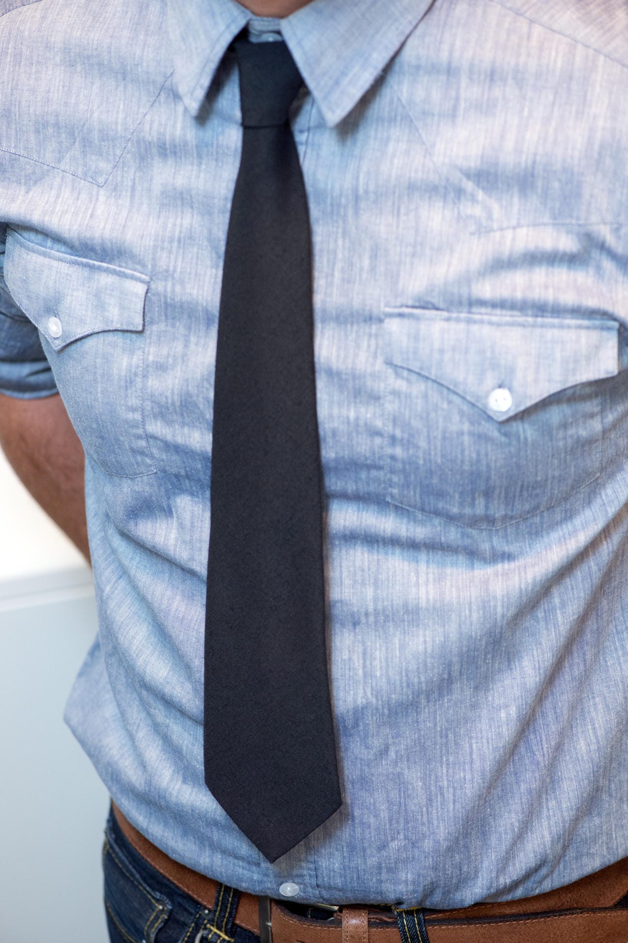 Schmale, dezente und kürzere Krawatten liegen derzeit im Trend. Aber: Maximal eine Handbreit darf zwischen Krawattenspitze und Hosenbund passen.