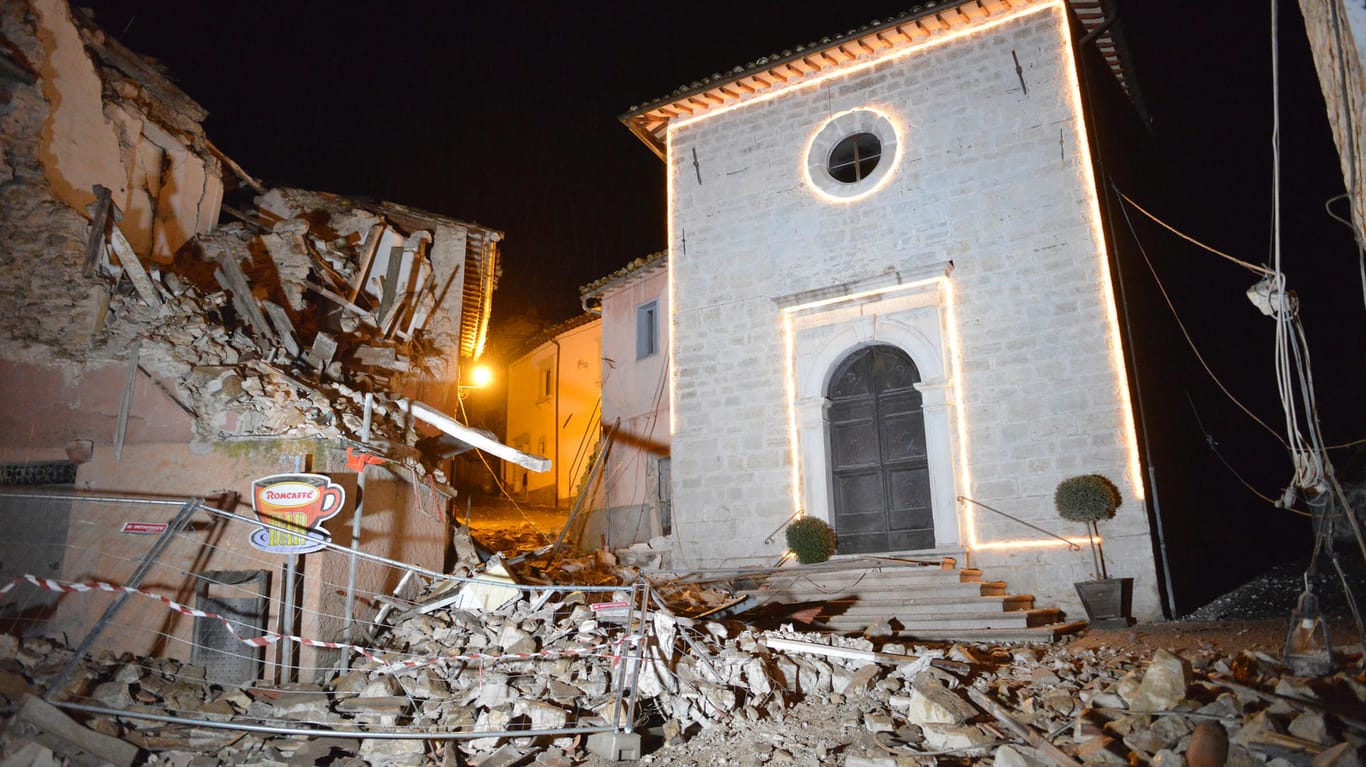 Die Kirche von San Sebastiano steht nach einem heftigen Erdbeben inmitten beschädigter Häuser in Castelsantangelo sul Nera.