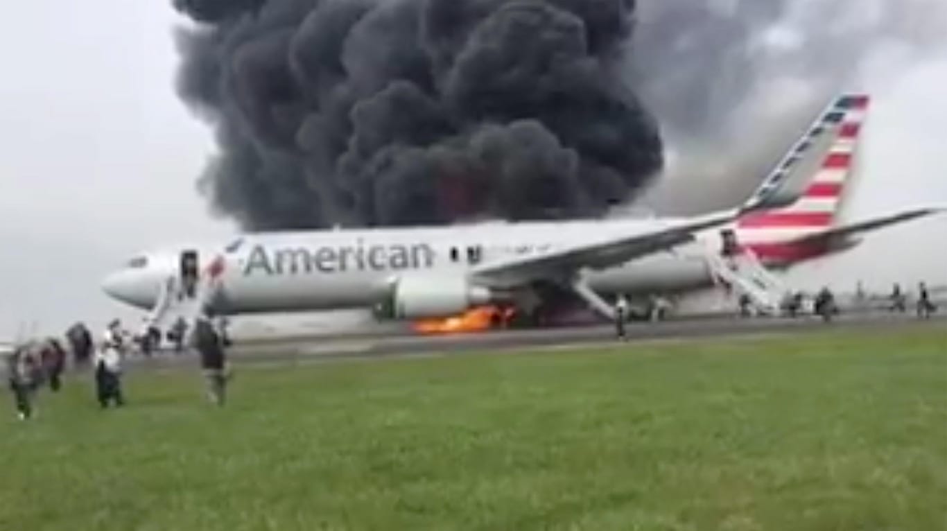 Über der Boeing 767 der Fluggesellschaft American Airlines steigen dicke Rauchwolken auf.