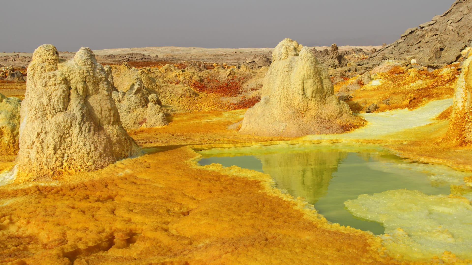 Anblicke wie nicht von dieser Welt: Der abgelagerte Schwefel der Dallol-Senke schimmert in Gelbschattierungen, aus weißen Salztürmen brodelt Wasser hervor.