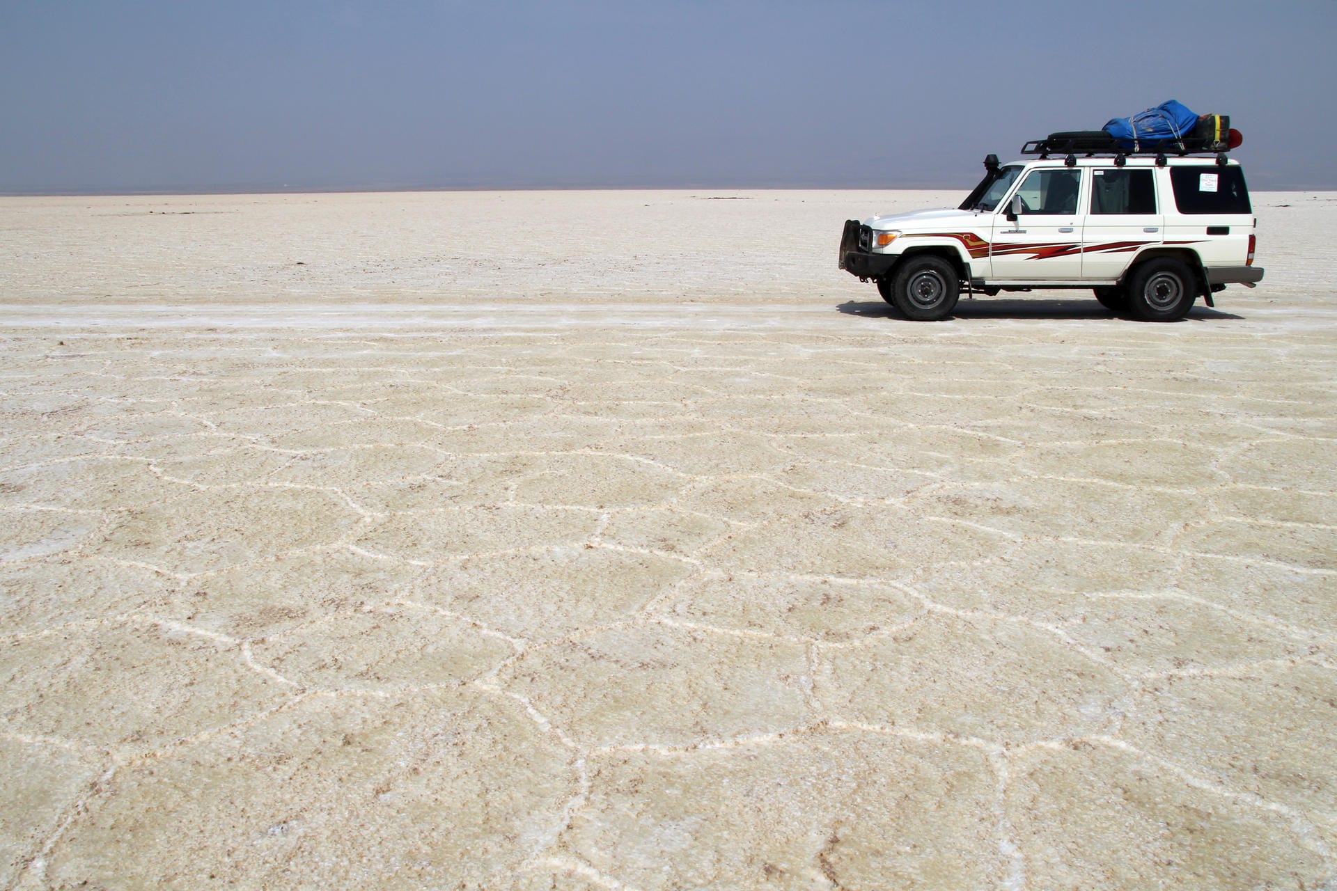 Eine weitere Unwirklichkeit der Region: Die Jeeps der Tourgruppen fahren über die flache Salzpfanne der Dallol-Senke in der nordäthiopischen Danakil-Wüste.