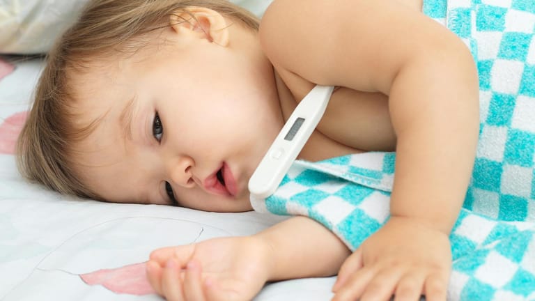 Bei einem Kind wird die Körpertemperatur gemessen: Bei einem Fieberkrampf steigt die Temperatur schnell an und das Kind bekommt Krämpfe am ganzen Körper.