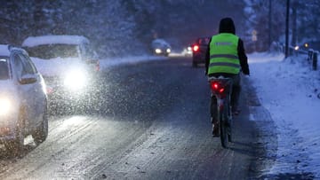 Tief "Husch" hat den Schnee auch in den Norden gebracht. Am Dienstagmorgen muss sich ein Fahrradfahrer in Norderstedt in Schleswig-Holstein über die glatten Straßen kämpfen.