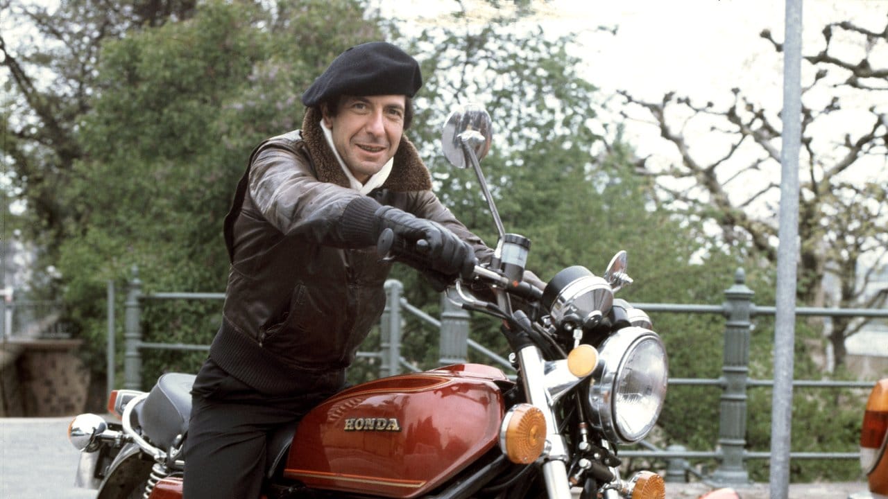 Der kanadische Sänger Leonard Cohen auf einem Motorrad (1976).