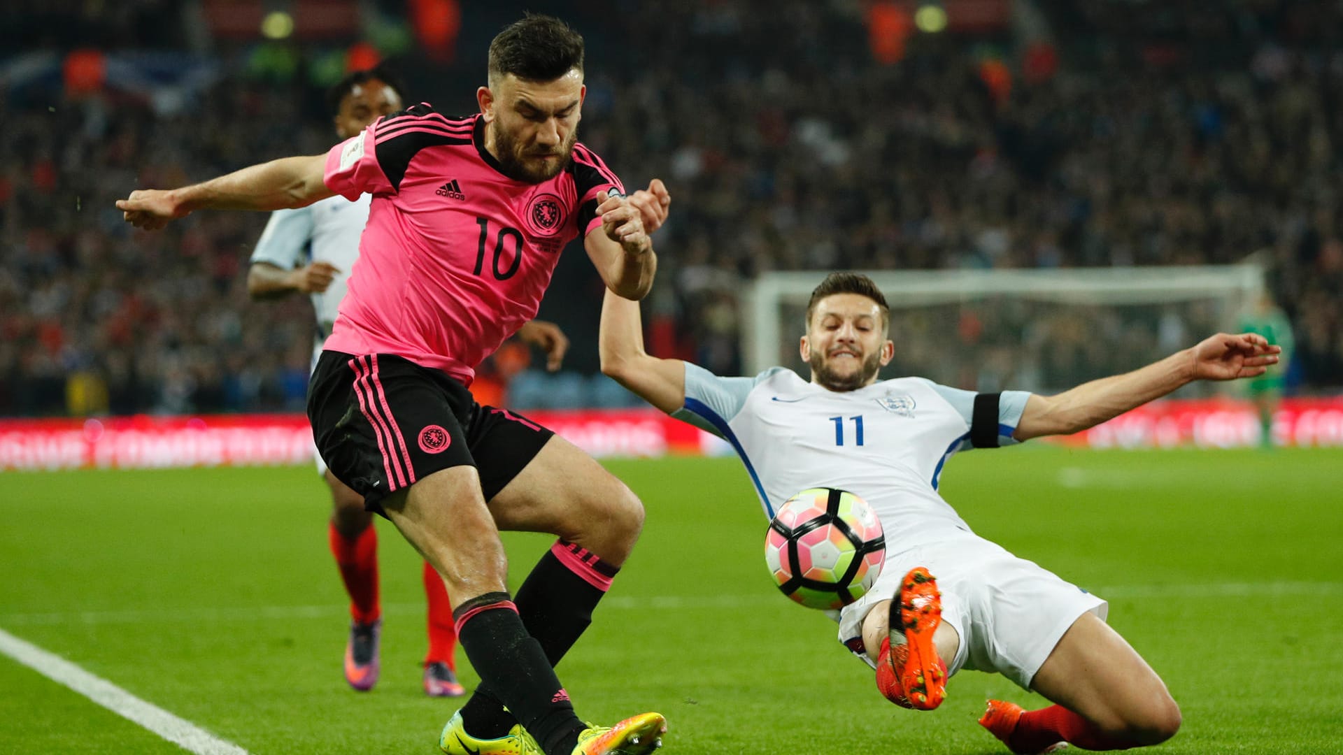 Englands Adam Lallana (re.) versucht den Schotten Robert Snodgrass vom Ball zu trennen.