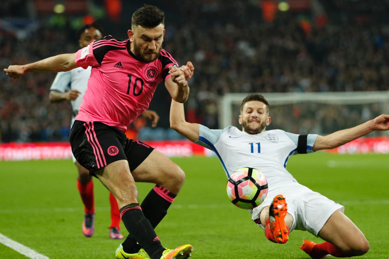 Englands Adam Lallana (re.) versucht den Schotten Robert Snodgrass vom Ball zu trennen.