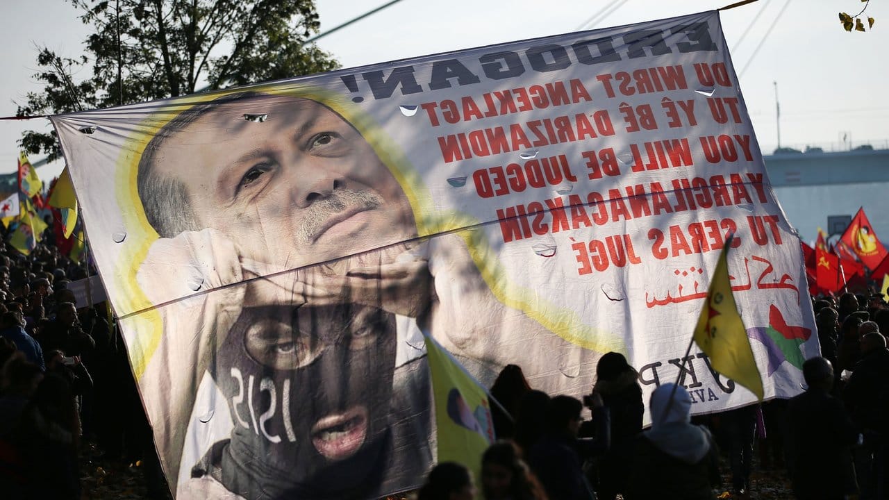 "Du wirst angeklagt" - Demonstranten halten ein Erdogan-kritisches Banner.